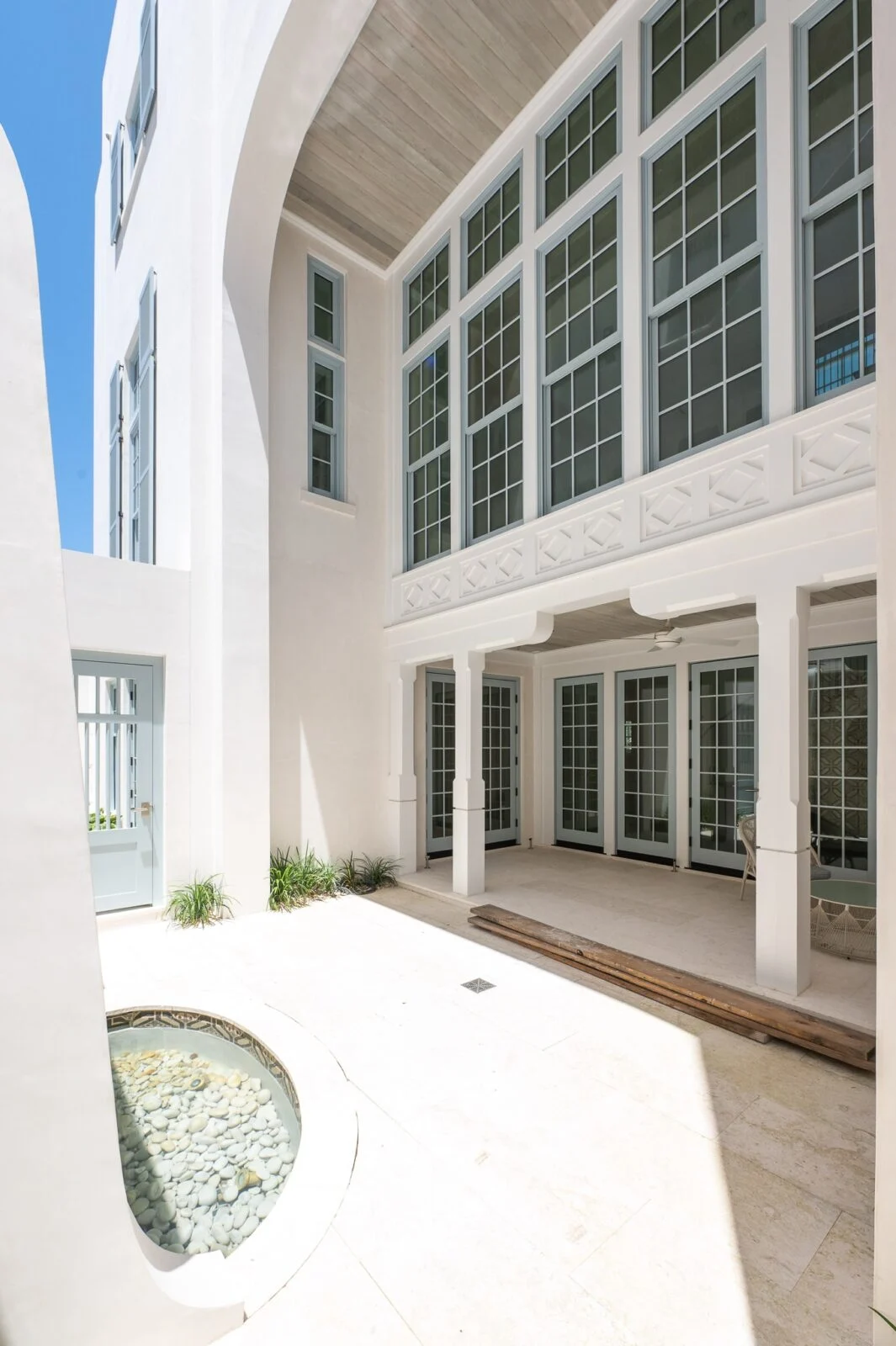 Old Cellar Lane Patio Area – Alys Beach Millwork by E. F. San Juan Courtyard in Alys Beach featuring custom gates, ceiling parts, and Loewen windows and doors provided by E. F. San Juan